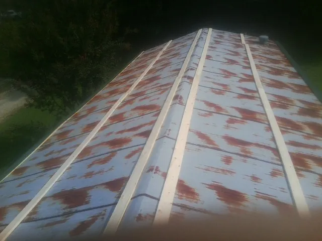 Rusted metal roof panels with new wood purlins before replacement — Storm Damage Roof Repair in Currituck by Roofing Brothers