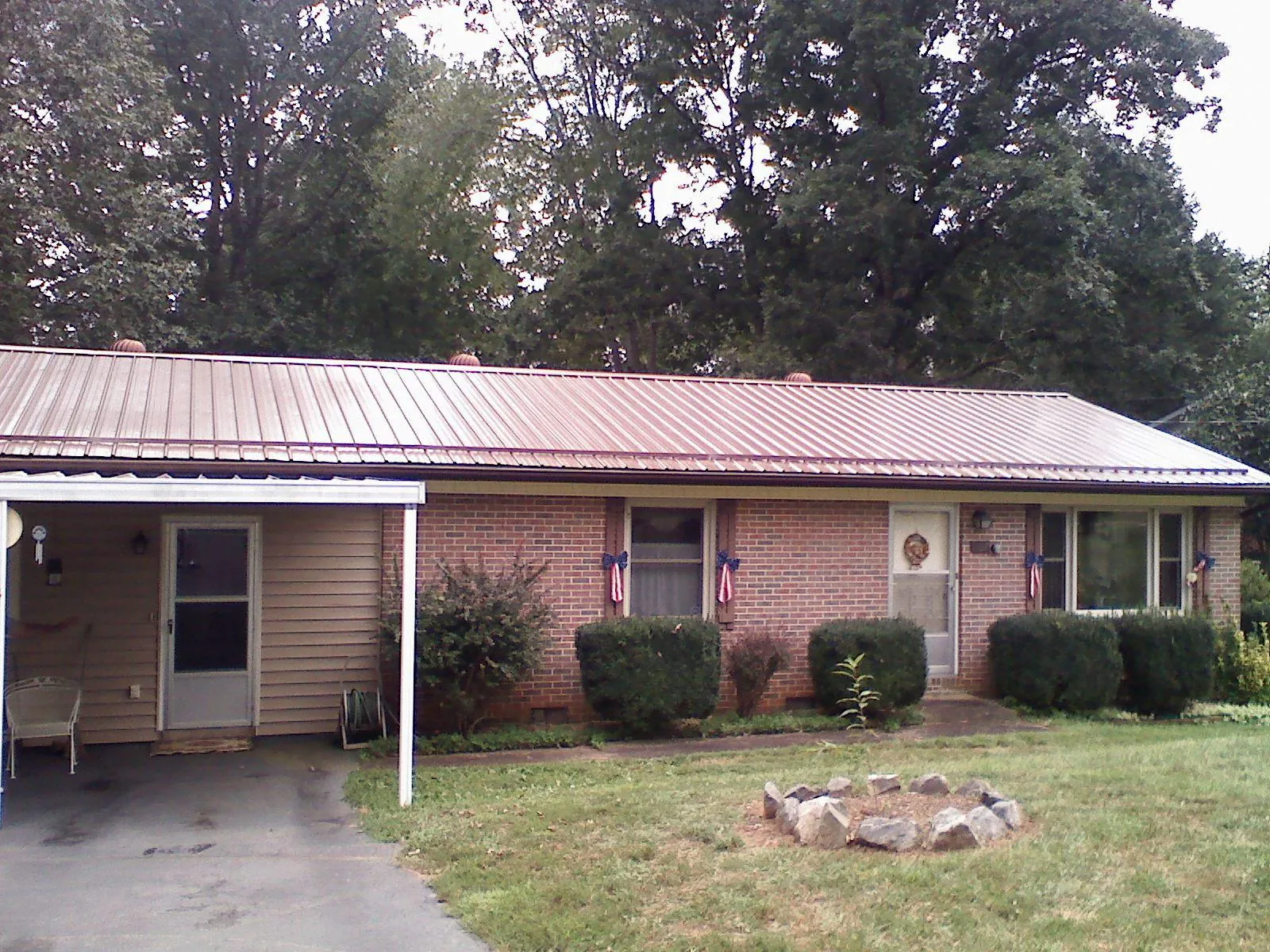Bronze metal roof and carport on a brick ranch home — Roof Repair work by our crew in Currituck